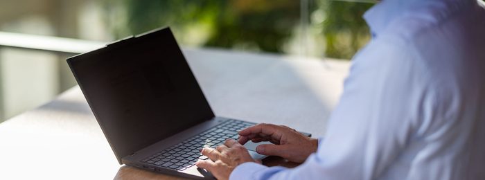 Hænder på et tastatur ved en bærbar computer